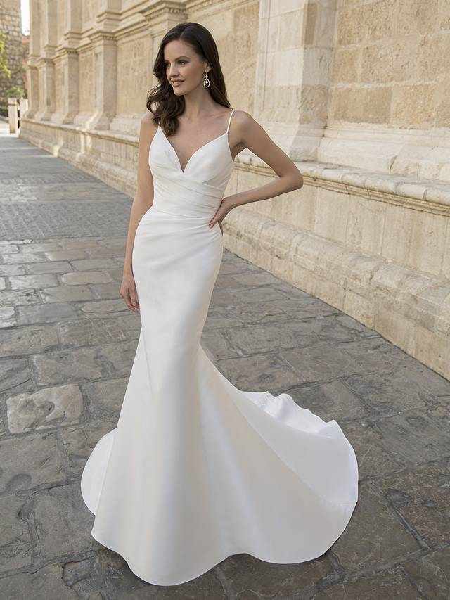 Code:Etoile Marilyn For all our gorgeous minimalist brides, MARILYN is a picture-perfect, modern mermaid wedding dress. This figure-flattering Mikado gown features a clean side-draped bodice with delicate spaghetti straps for a sophisticated, glamorous look. The sleek skirt is subtly layered for a light and flowy feel, cascading down into a chic, classic train with sweet buttons trailing down to the hem.Colour Options: Ivory