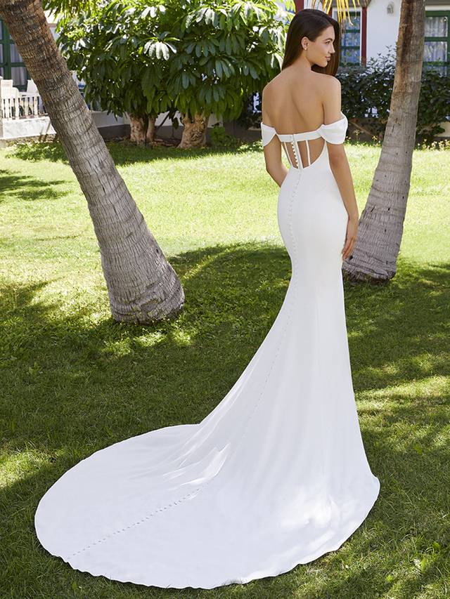 Code: Enzoani Love Brianna Shine bright in Brianna. Perfect for our flirty, modern brides, this beautiful stretch georgette mermaid wedding dress comfortably hugs the body, enhancing those curves. The classic sweetheart neckline, off-shoulder sleeves and pleated bodice detailing add extra romance to this sleek bridal look. Get ready for those incredible back shots with a one-of-kind illusion corset back, made sweeter with top to bottom fabric buttons.Colour Options: Ivory/Nude OR Ivory/Ivory