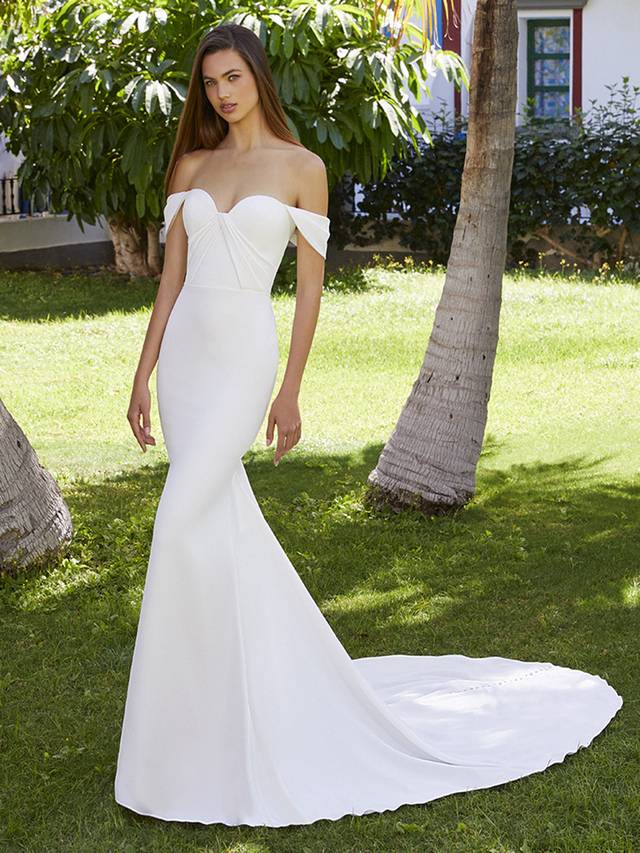 Code: Enzoani Love Brianna Shine bright in Brianna. Perfect for our flirty, modern brides, this beautiful stretch georgette mermaid wedding dress comfortably hugs the body, enhancing those curves. The classic sweetheart neckline, off-shoulder sleeves and pleated bodice detailing add extra romance to this sleek bridal look. Get ready for those incredible back shots with a one-of-kind illusion corset back, made sweeter with top to bottom fabric buttons.Colour Options: Ivory/Nude OR Ivory/Ivory