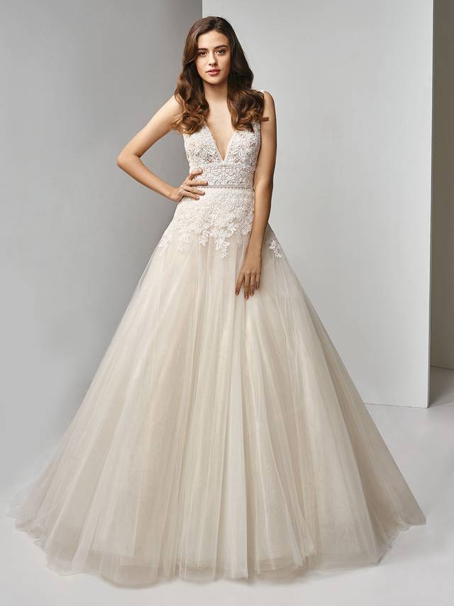 Code: Enzoani Beautiful BT19-10 Code: Enzoani Beautiful BT19-10 Sweet floral motifs adorn this modified A-line gown for the most striking, romantic look. The plunging V-neck continues its flattering design to the low V-back where an invisible back zipper closure helps cinch in the waist on the dreamiest, flowing tulle skirt.Colour Options : Ivory/Beige OR Ivory/Ivory