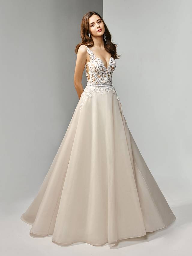 Code: Enzoani Beautiful BT19-11 Code: Enzoani Beautiful BT19-11 Modern and flirty, this A-line, organza gown is guaranteed to keep you the center of attention. The bodice features a dreamy, deep V-neckline accentuated with sweet embroidered lace. Crystal buttons adorn the low V-back for a sparkling finishing touch.Colour Options : Dark Ivory/Ivory/Nude Or Dark Ivory/Ivory/Ivory