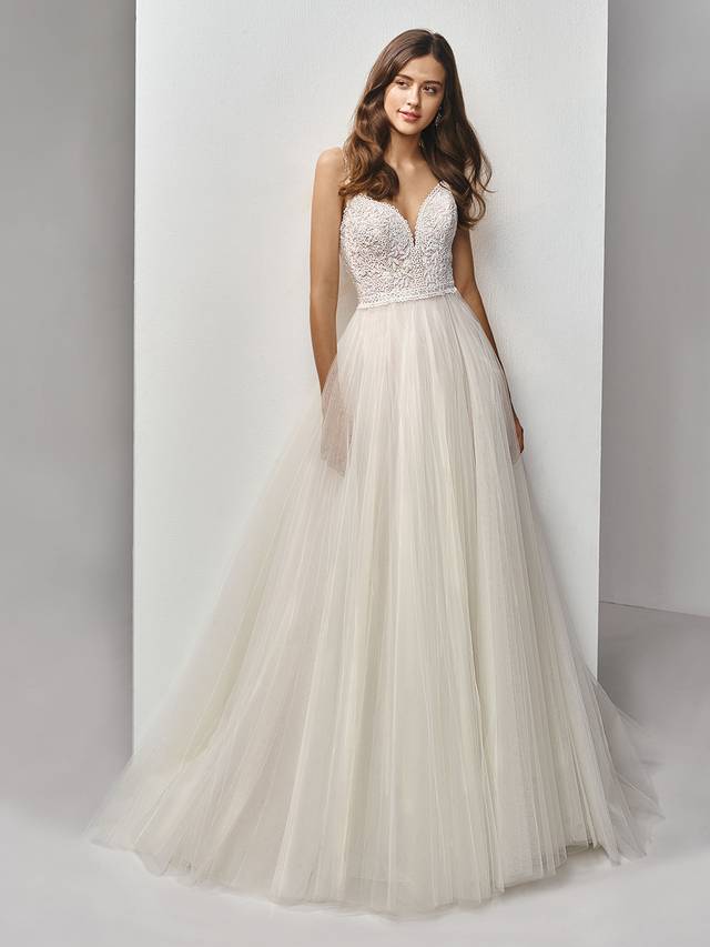 Code: Enzoani Beautiful BT19-16 Code: Enzoani Beautiful BT19-16 Effortlessly romantic, this full-length, A-line gown is a perfect modern fairytale dress. A skirt of flowing tulle layers creates the dreamiest effect to balance out the intricate embroidered lace on the bodice with a deep sweetheart neckline and delicate lace straps. A matching, low illusion back with covered buttons provides just the right touch of allure to finish the sweet look.Colour Options : Ivory/Latte OR Ivory/Ivory