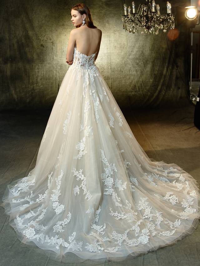 Code: Enzoani Blue Landry Code: Enzoani Blue Landry A captivating A-line gown with beautiful beaded, embroidered lace and chantilly lace. The dreamy tulle skirt is sprinkled with perfectly placed lace appliques that flow whimsically from the deep, strapless sweetheart illusion bodice with a lined front and unlined sides. An intricate, unlined illusion back with crystal buttons is the perfect modern complement.Colour Options : Ivory/Beige OR Ivory/Ivory