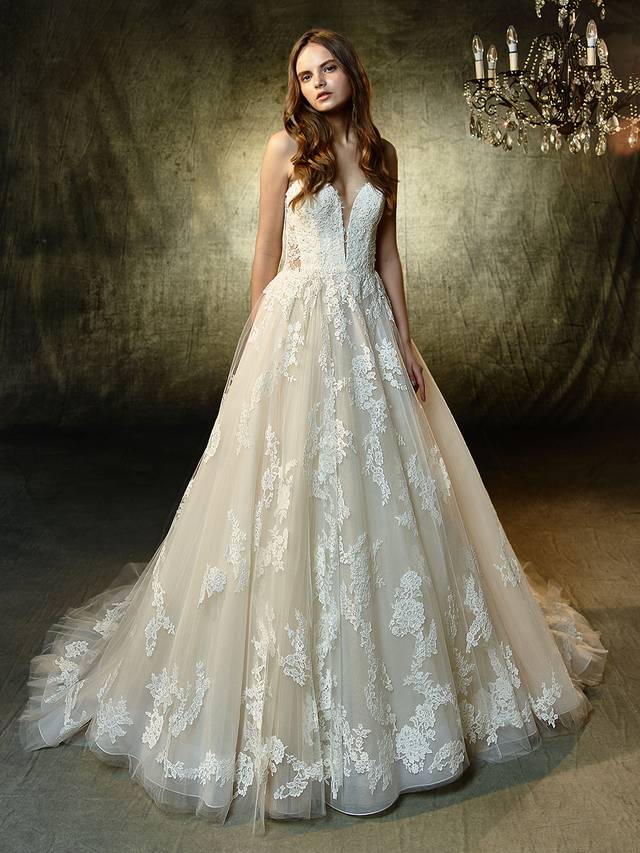 Code: Enzoani Blue Landry Code: Enzoani Blue Landry A captivating A-line gown with beautiful beaded, embroidered lace and chantilly lace. The dreamy tulle skirt is sprinkled with perfectly placed lace appliques that flow whimsically from the deep, strapless sweetheart illusion bodice with a lined front and unlined sides. An intricate, unlined illusion back with crystal buttons is the perfect modern complement.Colour Options : Ivory/Beige OR Ivory/Ivory