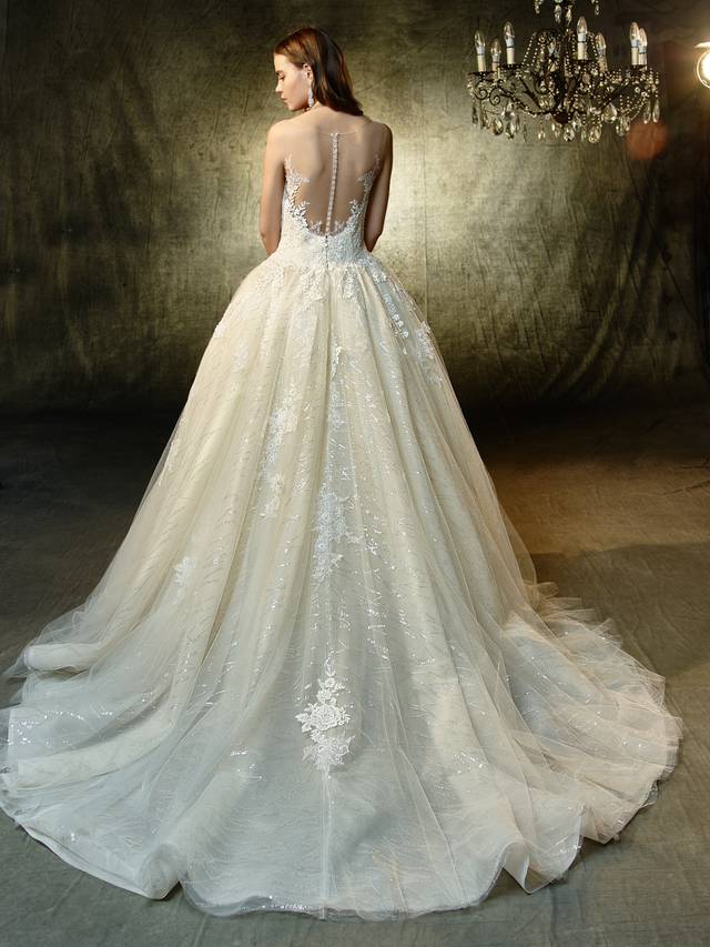 Code: Enzoani Blue Langley Code: Enzoani Blue Langley Delicate but not short on the sparkle factor, this full A-line gown will dazzle and delight the sweetest bride. The illusion V-neck bodice is adorned with graceful lace details that lead to a gorgeous illusion open back that mimics the same details. A spectacular unity of sequin embroidered lace, chantilly lace and sequin tulle adds a touch of play and whimsy to a beautifully timeless silhouette.Colour Options : Ivory/Beige OR Ivory/Ivory