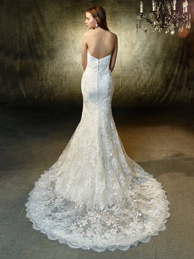 Code: Enzoani Blue Laura Code: Enzoani Blue Laura A classic strapless sweetheart mermaid gown becomes a blooming beauty with gorgeous floral-shaped appliques of beaded, embroidered lace and chantilly lace sprinkled atop the soft stretch georgette fabric. Delicately scalloped hem lace creates even more sweetness, while covered buttons add the finishing touch along the invisible back zipper.Colour Options : Ivory