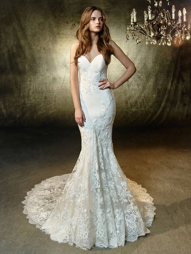 Code: Enzoani Blue Laura Code: Enzoani Blue Laura A classic strapless sweetheart mermaid gown becomes a blooming beauty with gorgeous floral-shaped appliques of beaded, embroidered lace and chantilly lace sprinkled atop the soft stretch georgette fabric. Delicately scalloped hem lace creates even more sweetness, while covered buttons add the finishing touch along the invisible back zipper.Colour Options : Ivory