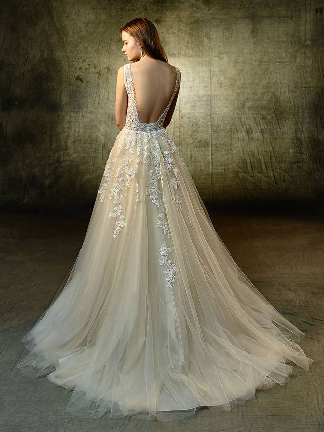 Code: Enzoani Blue Lavender - IN STUDIO Code: Enzoani Blue Lavender - IN STUDIO As sweet as can be with an undeniable allure, this modified A-line beauty is sure to captivate. The unlined V-neckline bodice has a beautiful scalloped lace edge that is complemented with the prettiest floral motif appliques. A bejeweled belt dazzles at the waistline as delicately placed lace appliques and tulle form a cascading, dreamy skirt. A lace framed, low open back is the sweetest detail to finish off the look.Colour Optons : Ivory/Beige OR Ivory/Ivory