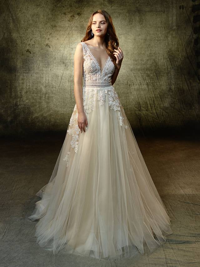 Code: Enzoani Blue Lavender - IN STUDIO Code: Enzoani Blue Lavender - IN STUDIO As sweet as can be with an undeniable allure, this modified A-line beauty is sure to captivate. The unlined V-neckline bodice has a beautiful scalloped lace edge that is complemented with the prettiest floral motif appliques. A bejeweled belt dazzles at the waistline as delicately placed lace appliques and tulle form a cascading, dreamy skirt. A lace framed, low open back is the sweetest detail to finish off the look.Colour Optons : Ivory/Beige OR Ivory/Ivory