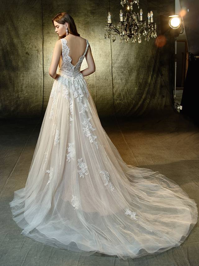 Code: Enzoani Blue Lexanne - IN STUDIO Code: Enzoani Blue Lexanne - IN STUDIO Enchant the entire crowd in this ultra-sweet, full-length A-line gown. A plunging sweetheart neckline is framed with soft beaded corded lace straps to match the intricate lace bodice, waist band, and appliques gracefully sprinkled down the dreamy tulle skirt. The train ends in a horsehair hem for a subtle yet modern effect to complement the detailed, scalloped lace V-back.Colour Options : Ivory/Latte OR Ivory/Ivory