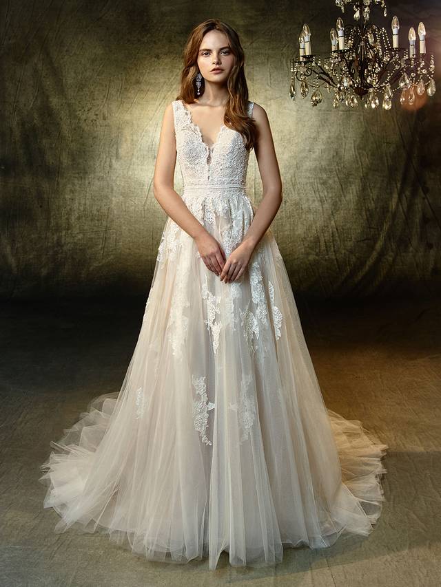 Code: Enzoani Blue Lexanne - IN STUDIO Code: Enzoani Blue Lexanne - IN STUDIO Enchant the entire crowd in this ultra-sweet, full-length A-line gown. A plunging sweetheart neckline is framed with soft beaded corded lace straps to match the intricate lace bodice, waist band, and appliques gracefully sprinkled down the dreamy tulle skirt. The train ends in a horsehair hem for a subtle yet modern effect to complement the detailed, scalloped lace V-back.Colour Options : Ivory/Latte OR Ivory/Ivory