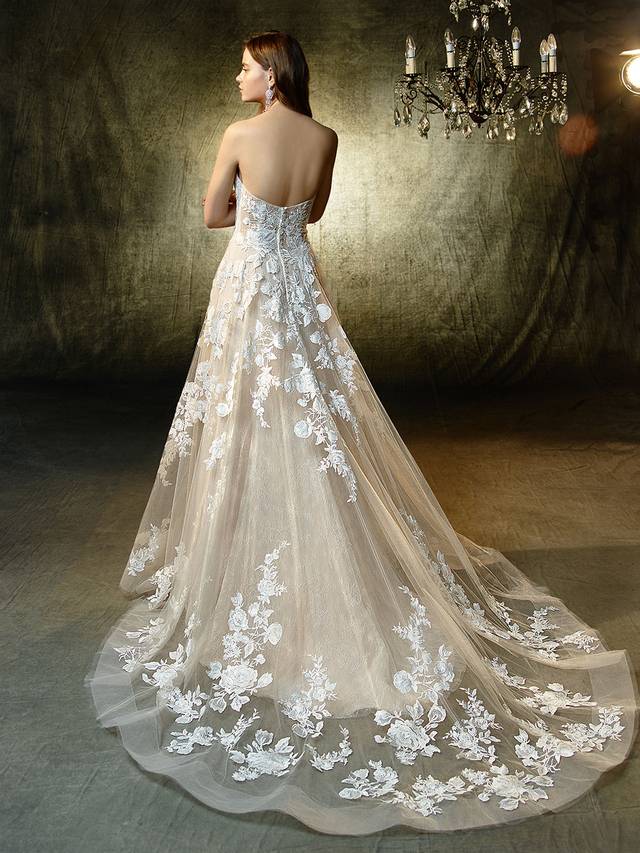 Code: Enzoani Blue Lila Code: Enzoani Blue Lila Sweet, classic and romantic, with a sexy, modern twist -- this full-length, A-line gown features a plunging, illusion strapless sweetheart neckline with unlined sides matching an unlined illusion back. Exquisite embroidered lace and delicate chantilly lace appliques embellish the soft tulle skirt with horsehair hem for a playful, modern effect.Colour Options : Ivory/Latte OR Ivory/Ivory