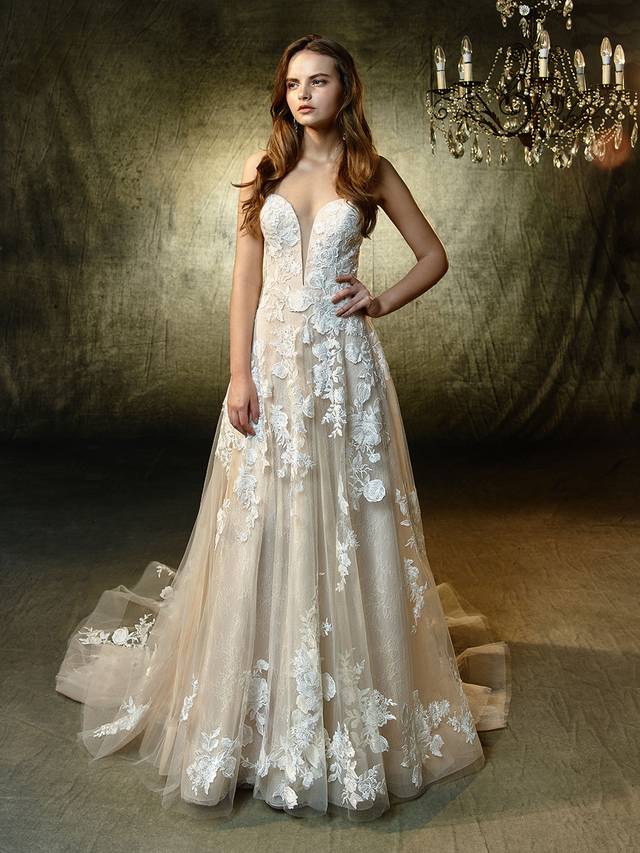 Code: Enzoani Blue Lila Code: Enzoani Blue Lila Sweet, classic and romantic, with a sexy, modern twist -- this full-length, A-line gown features a plunging, illusion strapless sweetheart neckline with unlined sides matching an unlined illusion back. Exquisite embroidered lace and delicate chantilly lace appliques embellish the soft tulle skirt with horsehair hem for a playful, modern effect.Colour Options : Ivory/Latte OR Ivory/Ivory