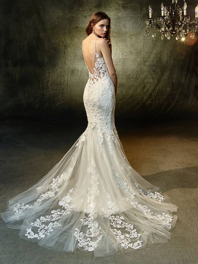 Code: Enzoani Blue Lilac Code: Enzoani Blue Lilac Romantic and alluring, this full-length mermaid gown features a plunging sweetheart neckline framed by sparkling spaghetti straps that trail down to form a low, illusion V-back. The sweetest beaded, embroidered lace on the bodice continues down to the soft tulle skirt and train, creating a mesmerizing effect for that walk down the aisle.Colour Options : Ivory/Beige OR Ivory/Ivory