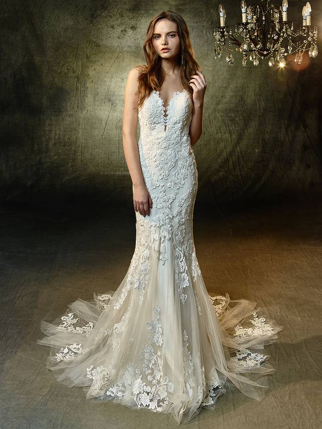 Code: Enzoani Blue Lilac Code: Enzoani Blue Lilac Romantic and alluring, this full-length mermaid gown features a plunging sweetheart neckline framed by sparkling spaghetti straps that trail down to form a low, illusion V-back. The sweetest beaded, embroidered lace on the bodice continues down to the soft tulle skirt and train, creating a mesmerizing effect for that walk down the aisle.Colour Options : Ivory/Beige OR Ivory/Ivory