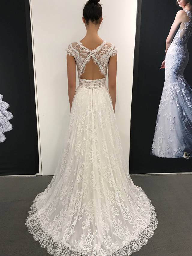 Code: Enzoani Blue Lillium Code: Enzoani Blue Lillium All eyes on the bride with this jaw-dropping gown. This A-line gown features an exquisite plunging V-neckline and curve-hugging empire waist to complement the delicate triangle back. Soft, detailed Chantilly lace is placed over the gown to give the illusion of walking on air.Colour Options : Ivory