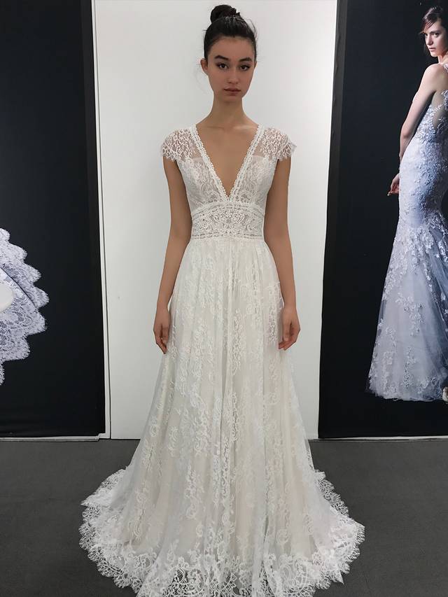 Code: Enzoani Blue Lillium Code: Enzoani Blue Lillium All eyes on the bride with this jaw-dropping gown. This A-line gown features an exquisite plunging V-neckline and curve-hugging empire waist to complement the delicate triangle back. Soft, detailed Chantilly lace is placed over the gown to give the illusion of walking on air.Colour Options : Ivory