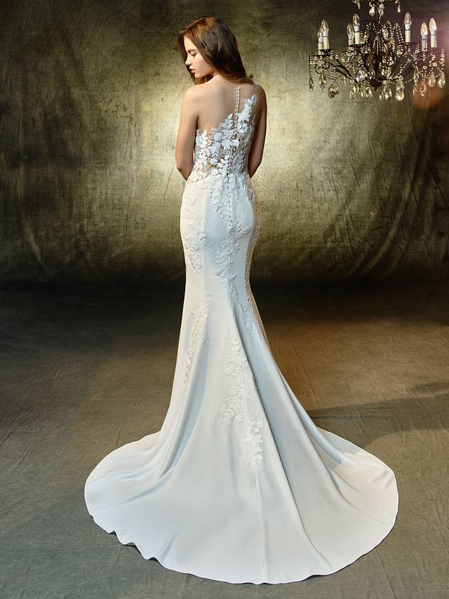 Code: Enzoani Blue Linwood Code: Enzoani Blue Linwood Lovely at every turn -- this full-length mermaid gown is a vision of sweet embroidered lace and chantilly lace standing out atop soft and sleek stretch georgette fabric and an illusion tulle scoop neckline. Crystal buttons along the back add a touch of sparkle, and an invisible back zipper provides a clean finishing touch.Colour Options : Ivory/Champagne OR Ivory/Ivory