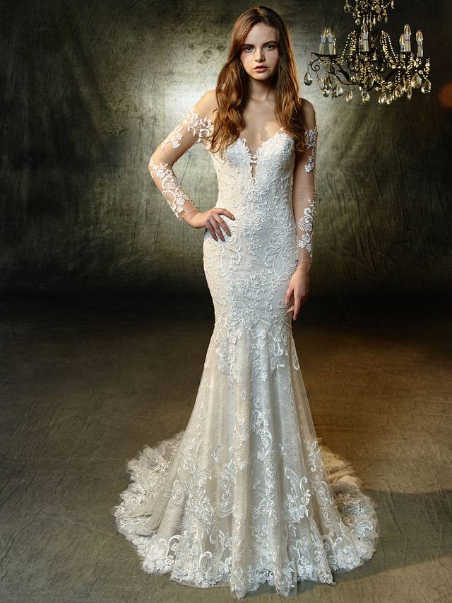 Code: Enzoani Blue Lonnie Code: Enzoani Blue Lonnie For the modern bride searching for a timeless, sophisticated look -- this full-length mermaid gown features elegant, long tulle sleeves embellished with sequin embroidered and chantilly lace. A matching deep sweetheart neckline bodice is perfect with a sexy, low illusion back adorned with crystal buttons and an invisible zipper.Colour Options : Ivory/Beige/Sand OR Ivory/Ivory