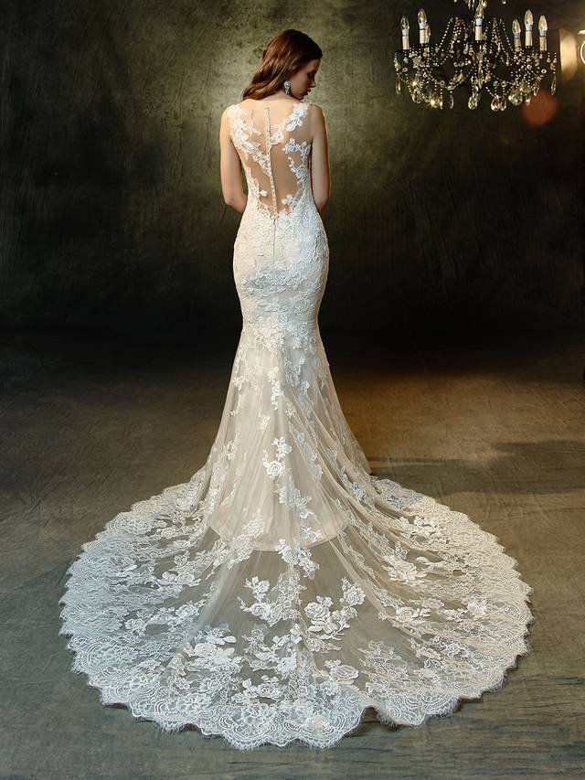 Code: Enzoani Blue Lorena Code: Enzoani Blue Lorena Impress from every angle in this full-length mermaid gown made of exquisitely beaded, embroidered lace and chantilly lace. An illusion bateau sweetheart neckline and matching illusion back are graced with delicate lace appliques that sprinkle throughout the rest of the gown and down the soft tulle skirt, ending in gorgeous scalloped hem lace. Finished with sparkling crystal buttons and an invisible back zipper closure.Colour Options : Ivory/Beige/Sand OR Ivory/Ivory/Ivory