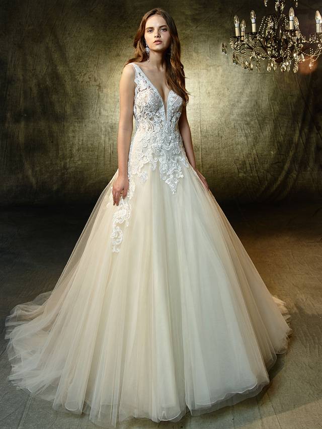 Code: Enzoani Blue Louella Code: Enzoani Blue Louella Sure to steal hearts, this full-length, A-line gown is modern, romantic, and enchanting all at once. Captivating sequin Venice lace adorns the plunging, illusion V-neck bodice and matching low V-back while cascading down the train of the dreamiest tulle skirt for a gorgeous waterfall effect. Crystal buttons and an invisible back zipper closure complete the stunning look.Colour Options : Ivory/Beige OR Ivory/Ivory