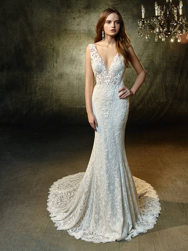 Code: Enzoani Blue Lucy Code: Enzoani Blue Lucy Lovely in lace -- this full-length mermaid gown is what romantic lace dress dreams are made of. A plunging illusion bodice with V-neckline extends to a low, illusion V-back that's sure to captivate all your guests. All-over, embroidered lace becomes an exquisite vision, with scalloped hem lace and an invisible back zipper closure providing the finishing touches.Colour Options : Ivory/Sand OR Ivory/Ivory