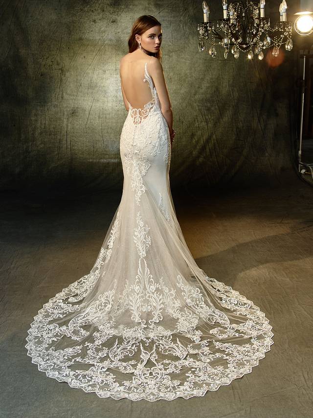 Code: Enzoani Blue Lunaire Code: Enzoani Blue Lunaire A gorgeously modern gown with vintage vibes and flair. This full-length mermaid gown features a plunging sweetheart neckline and illusion lace straps that extend into a breathtaking illusion keyhole back to keep everyone captivated as you come and go. Sequin, embroidered lace and delicate glitter tulle provides subtle, all-over sparkle while the spectacular scalloped hem lace train is guaranteed to be picture perfect.Colour Options : Ivory/Sand OR Ivory/Ivory