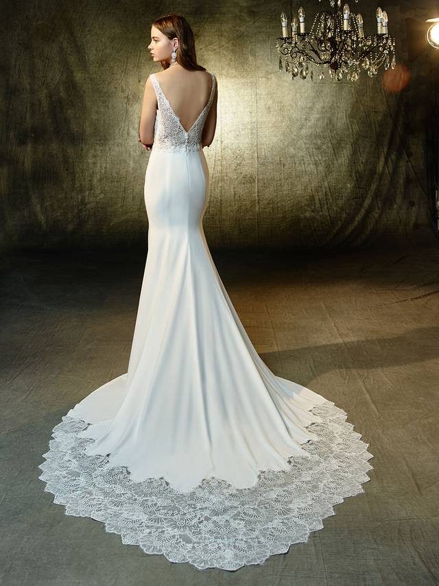 Code: Enzoani Blue Luz Code: Enzoani Blue Luz Chic, sleek, and sexy -- this full-length mermaid gown mixes the softest stretch georgette fabric with romantic beaded chantilly lace on the illusion bodice with plunging V-neckline and matching low, illusion V-back. A lace band at the waist softly cinches the figure and draws the eye down to the dazzling lace train. Finished with crystla buttons and an invisible back zipper closure.Colour Options : Ivory/Nude OR Ivory/Ivory