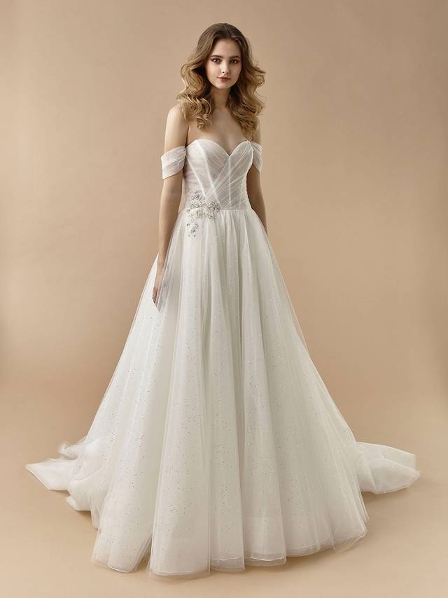 Code: Enzoani Beautiful BT20-03 Code: Enzoani Beautiful BT20-03 Like something out of a fairytale, BT20-3 is chic, minimalist, and ultra-romantic all in one. This A-line gown features versatile, detachable off-the-shoulder straps as well as gorgeous glitter tulle with a beautiful beaded embellishment at the hip.Colour Options: Ivory