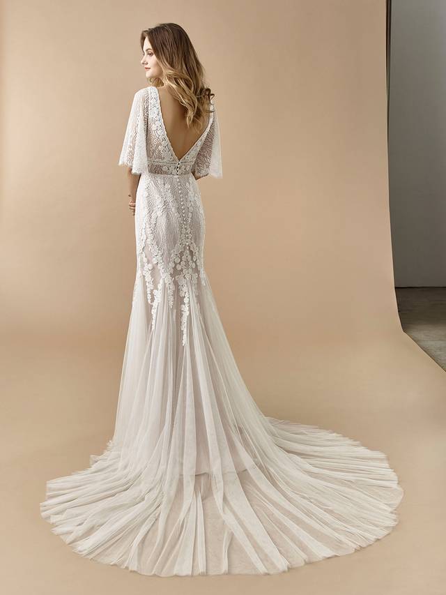 Code: Enzoani Beautiful BT20-05 Code: Enzoani Beautiful BT20-05 Perfect for the boho bride. This full-length mermaid gown is gorgeous at every turn with its fluttering, light lace sleeves and soft tulle skirt. A deep V-back adds a sexy, modern touch that is sure to captivate your guests. Covered buttons and an invisible zipper add final touches to this lovely look.Colour Options: Ivory/Latte OR Ivory/Ivory