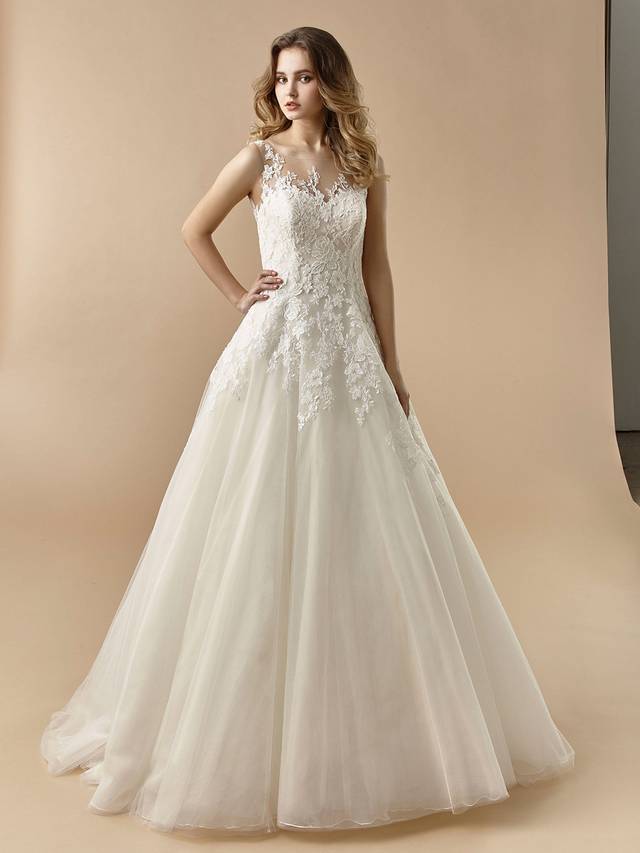 Code: Enzoani Beautiful BT20-07 Code: Enzoani Beautiful BT20-07 A classically sweet A-line style adorned with sweet lace over soft tulle, BT20-7 is sure to enchant your guests. A delicate illusion lace neckline matches the low, illusion lace back with covered buttons for the perfect romantic look.Colour Options: Ivory/Beige OR Ivory/Ivory