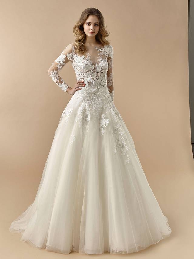 Code: Enzoani Beautiful BT20-21 Code: Enzoani Beautiful BT20-21 Searching for a timelessly elegant dress for the big day? Look no further. This gorgeous A-line gown features coveted long illusion lace sleeves, as well as an illusion lace sweetheart neckline complemented by a sexy, open V-back. Dreamy, airy tulle layers of the skirt are adorned with lace appliques, while buttons and an invisible zipper complete the look.Colour Options: Ivory/Pewter/Beige OR Ivory/Pewter/Ivory OR Ivory/Ivory/Ivory