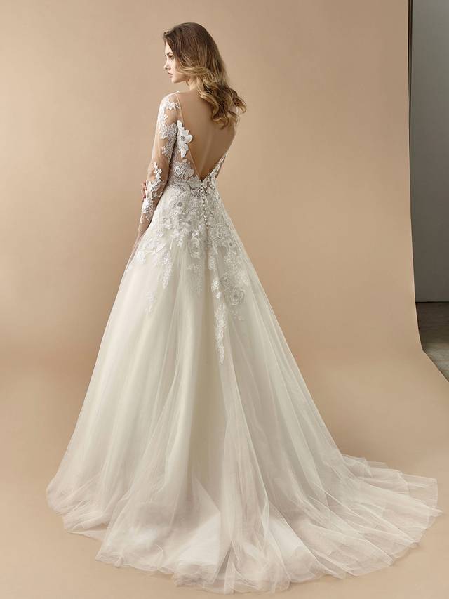 Code: Enzoani Beautiful BT20-21 Code: Enzoani Beautiful BT20-21 Searching for a timelessly elegant dress for the big day? Look no further. This gorgeous A-line gown features coveted long illusion lace sleeves, as well as an illusion lace sweetheart neckline complemented by a sexy, open V-back. Dreamy, airy tulle layers of the skirt are adorned with lace appliques, while buttons and an invisible zipper complete the look.Colour Options: Ivory/Pewter/Beige OR Ivory/Pewter/Ivory OR Ivory/Ivory/Ivory