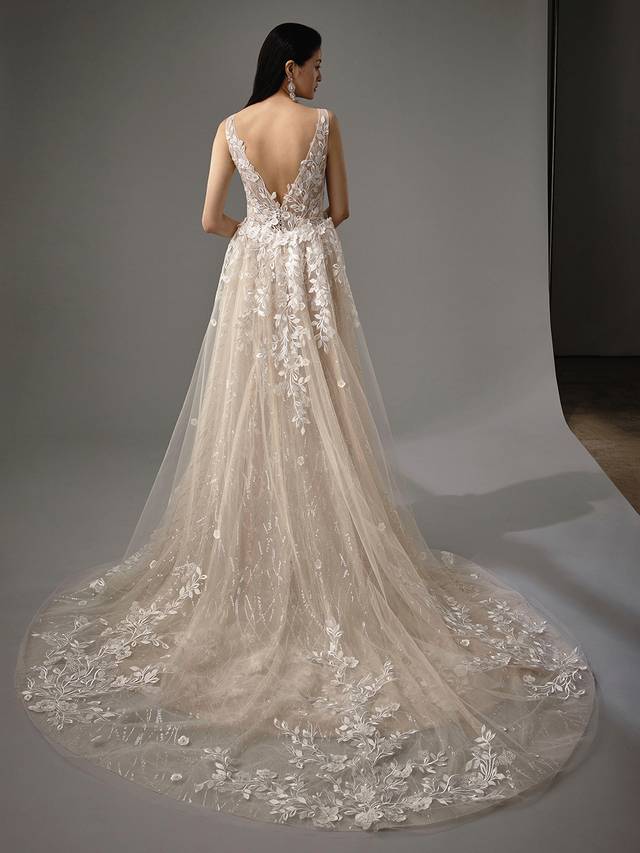 Code: Enzoani Blue - Mai with Detachable Skirt Code: Enzoani Blue - Mai with Detachable Skirt Gorgeous 3D floral motifs and the most exquisite sequined tulle take centre stage in this mermaid turned A-line gown. This two-in-one gown features a detachable train to go from ceremony to reception ready within seconds. A low V-back and crystal buttons finish this look for final feminine touches.Colour Options: Ivory/Nude/Nude OR Ivory/Ivory/Ivory OR Ivory/Ivory/Nude