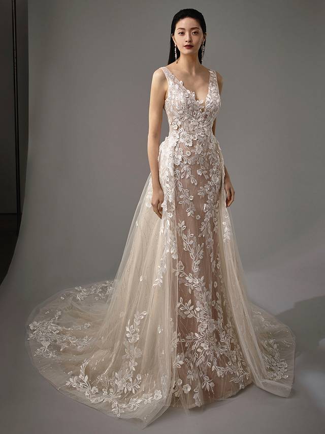 Code: Enzoani Blue - Mai with Detachable Skirt Code: Enzoani Blue - Mai with Detachable Skirt Gorgeous 3D floral motifs and the most exquisite sequined tulle take centre stage in this mermaid turned A-line gown. This two-in-one gown features a detachable train to go from ceremony to reception ready within seconds. A low V-back and crystal buttons finish this look for final feminine touches. Colour Options: Ivory/Nude/Nude OR Ivory/Ivory/Ivory OR Ivory/Ivory/Nude