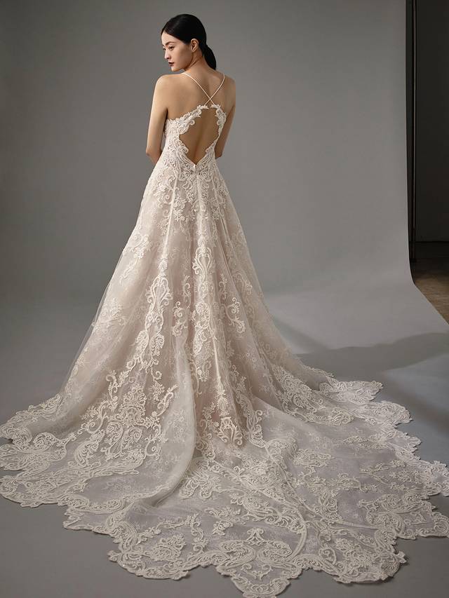 Code: Enzoani Blue - Manda Code: Enzoani Blue - Manda Chic, modern, feminine, this gown has it all. A V-neckline and all over regal lace are only the start as another lace layer is added below the skirt to give a 3D effect with movement. Straps criss-cross onto the back to create an alluring keyhole back with the most decadent lace design all the way through to the train.Colour Options: Ivory/Latte OR Ivory/Ivory