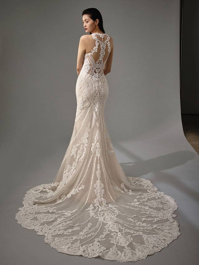 Code: Enzoani Blue - Marci Code: Enzoani Blue - Marci Blink and you'll miss. This mermaid gown offers a whimsical illusion neckline and back. Regal lace is carefully placed at the neck with just enough room between the traditional sweetheart neckline for a playful, sultry effect. More lace is meticulously added to the gown's jaw-dropping illusion, low-plunging back as it finishes with covered buttons along the spine.Colour Options: Ivory/Sand/Nude OR Ivory/Ivory/Ivory OR Ivory/Ivory/Nude OR Ivory/Nude/Nude