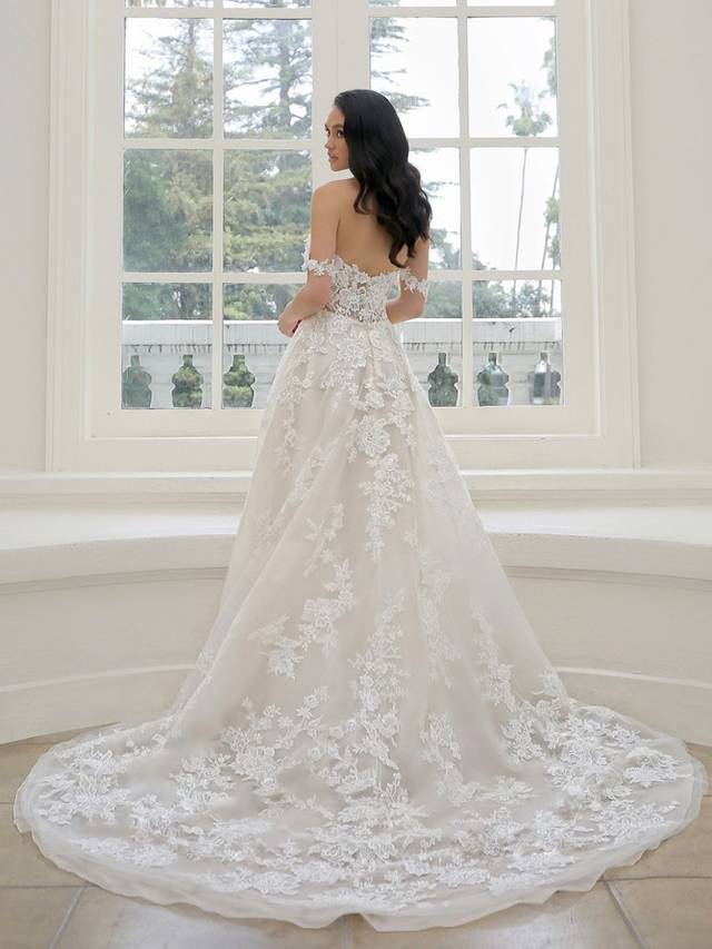 Code: Enzoani Blue - Mariane - IN STUDIO Code: Enzoani Blue - Mariane - IN STUDIO A gown made for the modern fairytale ending. This A-line gown features detachable floral off-shoulder sleeves with a sweetheart neckline for the ultimate romantic look. Lace cascades from the bodice to the tulle skirt and train of the gown making it something out of a dream.Colour Options: Ivory/Beige/Nude OR Ivory/Ivory/Ivory OR Ivory/Ivory/Nude