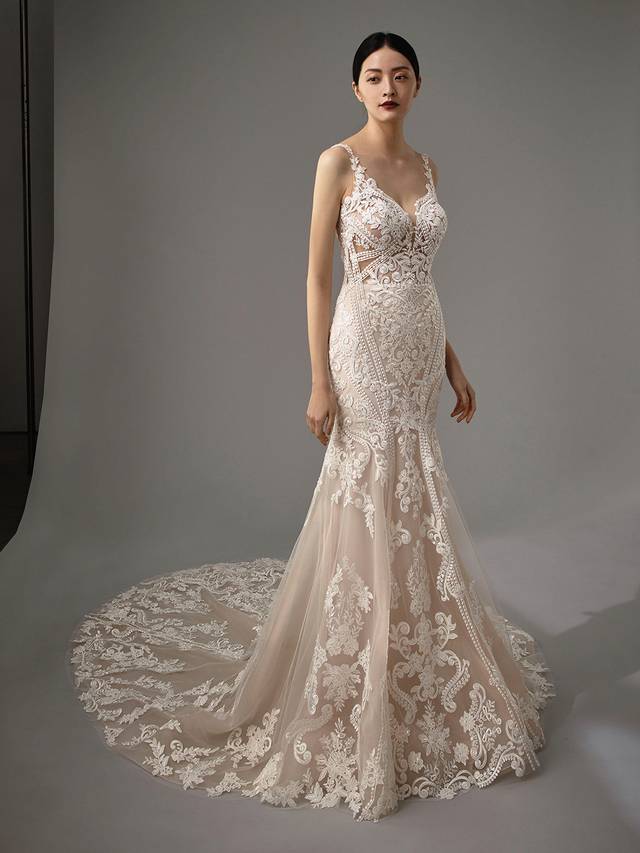 Code: Enzoani Blue - Marianna Code: Enzoani Blue - Marianna Vintage and classic meets modern and sultry. Regal lace covers this mermaid gown as it is carefully placed between the bodice, tulle skirt and train. Its low V-neckline is complemented by its low, sultry V-back, complete with a trail of covered buttons. A lace train finishes the look for a modern, romantic touch. Pair this gown with its veil.Colour Options: Ivory/Beige/Nude OR Ivory/Ivory/Ivory OR Ivory/Ivory/Nude OR Ivory/Nude/Nude