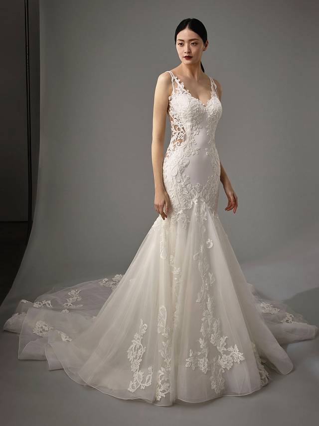 Code: Enzoani Blue - Maribel Code: Enzoani Blue - Maribel Ethereal with an air of modern chic. Flatter any figure with this mermaid gown's lateral lace illusion panels. Gorgeous chantlily lace is placed upon soft crepe with a skirt layered with the softest tulle. A lacy keyhole back adds an edgy feel, complemented by covered buttons trailing to the hem of a dreamy train.Colour Options: Ivory/Nude OR Ivory/Ivory