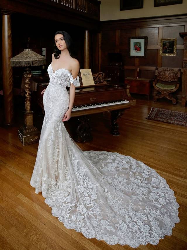Code: Enzoani Blue - Marija - IN STUDIO Code: Enzoani Blue - Marija - IN STUDIO Ethereal and whimsical elements are all crafted into one gown. With its mermaid silhouette and gorgeous tulle train, Marija is sure to captivate all eyes. Chantlily lace is placed throughout the gown with detachable floral, off-shoulder sleeves. This look is finished with covered buttons for a completely romantic look.Colour Options: Ivory/Beig OR Ivory/Ivory