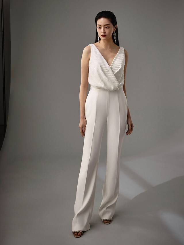 Code: Enzoani Blue - Marisabel Code: Enzoani Blue - Marisabel Edgy and chic, this is meant for the modern bride. Complete with the most exquisite beadwork at the bodice, Marisabel is sure to dazzle your guests. A low, open back adds an element of cheekiness. Move with ease and mobility as this jumpsuit finishes with sleek, pocketed trousers and an invisible zipper.Colour Options: Ivory OR Black