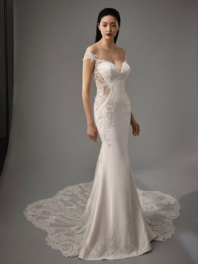 Code: Enzoani Blue - Marquise Code: Enzoani Blue - Marquise Elegance and romance are packed into one gorgeous stretch georgette gown. Alluring lace illusion panels on the sides are sure to highlight a bride's figure. Lace is carefully placed on the sweetheart neckline as it trails to the thigh. An alluring, low illusion back finishes the look with covered buttons cascading to the train's hem.Colour Options: Ivory/Nude OR Ivory/Ivory