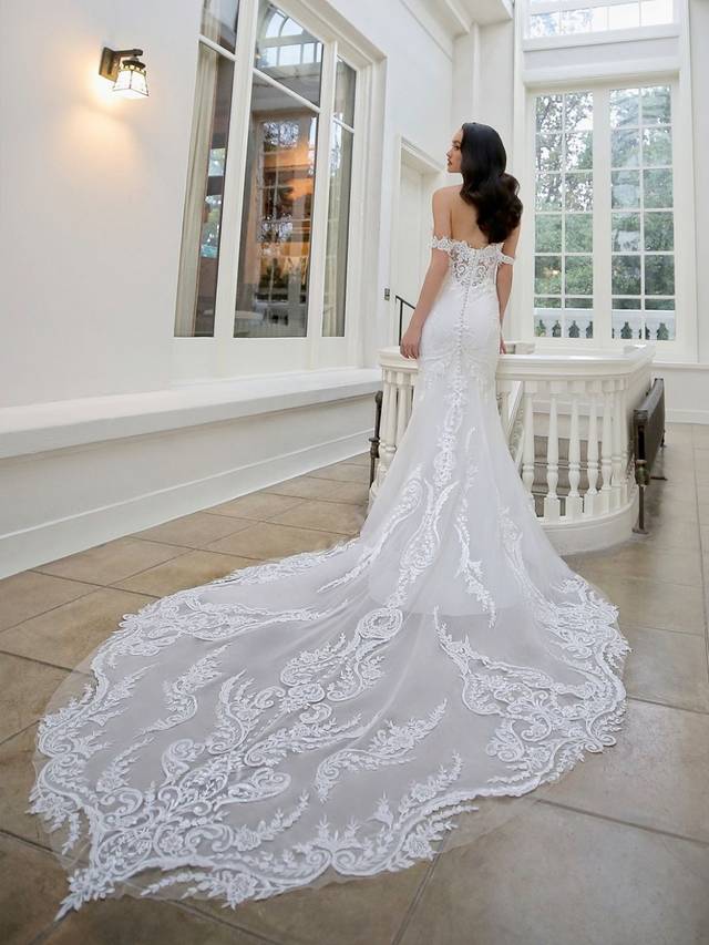 Code: Enzoani Blue - Martha - IN STUDIO Code: Enzoani Blue - Martha - IN STUDIO An alluring lace bodice with a sweetheart neckline and soft stretch georgette make the perfect combination for this elegant mermaid gown. Detachable off-the-shoulder sleeves are added for an extra romantic touch. A subtle lace illusion side panel adds a touch of playfulness. Covered buttons trail from the back to the end of its extravagant train.Colour Options: Ivory/Nude OR Ivory/Ivory