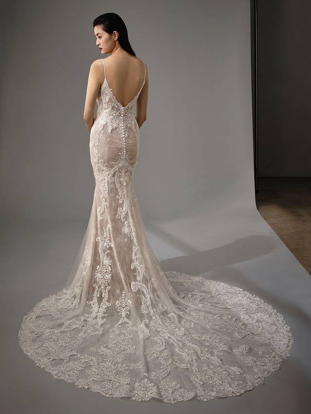 Code: Enzoani Blue - Martina Code: Enzoani Blue - Martina Dreamy and oh so romantic, this classic all-over lace mermaid gown is what you've been waiting for. Regal lace starts at the bodice with a low, plunging neckline. It cascades down to the tulle train with a delicate lace hem. A ruched bottom and covered buttons add a hint of playfulness Finished with a sexy, low V-back.Colour Options: Ivory/Nude/Nude OR Ivory/Ivory/Ivory OR Ivory/Ivory/Nude OR Ivory/Sand/Nude