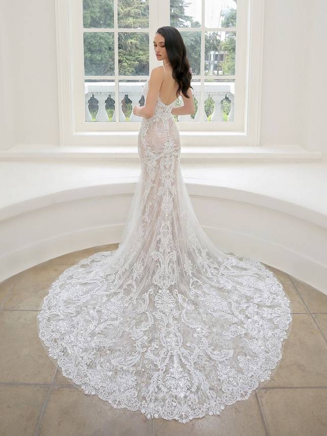 Code: Enzoani Blue - Martina - IN STUDIO Code: Enzoani Blue - Martina - IN STUDIO Dreamy and oh so romantic, this classic all-over lace mermaid gown is what you've been waiting for. Regal lace starts at the bodice with a low, plunging neckline. It cascades down to the tulle train with a delicate lace hem. A ruched bottom and covered buttons add a hint of playfulness Finished with a sexy, low V-back.Colour Options: Ivory/Nude/Nude OR Ivory/Ivory/Ivory OR Ivory/Ivory/Nude OR Ivory/Sand/Nude