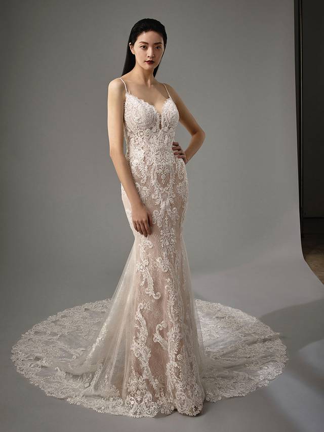 Code: Enzoani Blue - Martina Code: Enzoani Blue - Martina Dreamy and oh so romantic, this classic all-over lace mermaid gown is what you've been waiting for. Regal lace starts at the bodice with a low, plunging neckline. It cascades down to the tulle train with a delicate lace hem. A ruched bottom and covered buttons add a hint of playfulness Finished with a sexy, low V-back.Colour Options: Ivory/Nude/Nude OR Ivory/Ivory/Ivory OR Ivory/Ivory/Nude OR Ivory/Sand/Nude
