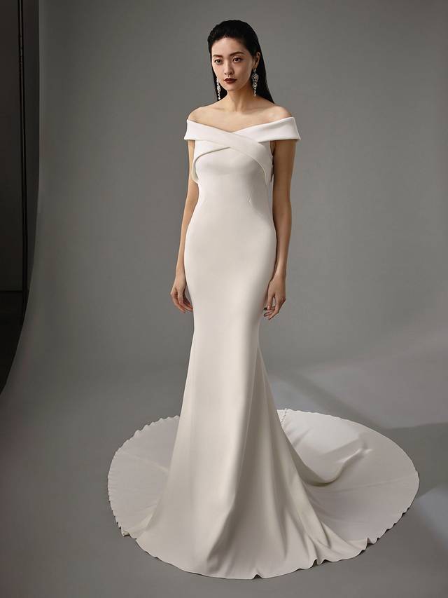 Code: Enzoani Blue - Maylin Code: Enzoani Blue - Maylin Chic and elegant, this gown was made for the modern bride. Soft crepe is used to create its mermaid silhouette, while off-shoulder details offer feminine touches along with a criss-cross keyhole back for added playfulness. Cascading covered buttons complete the ultimate sophisticated look.Colour Options: Ivory