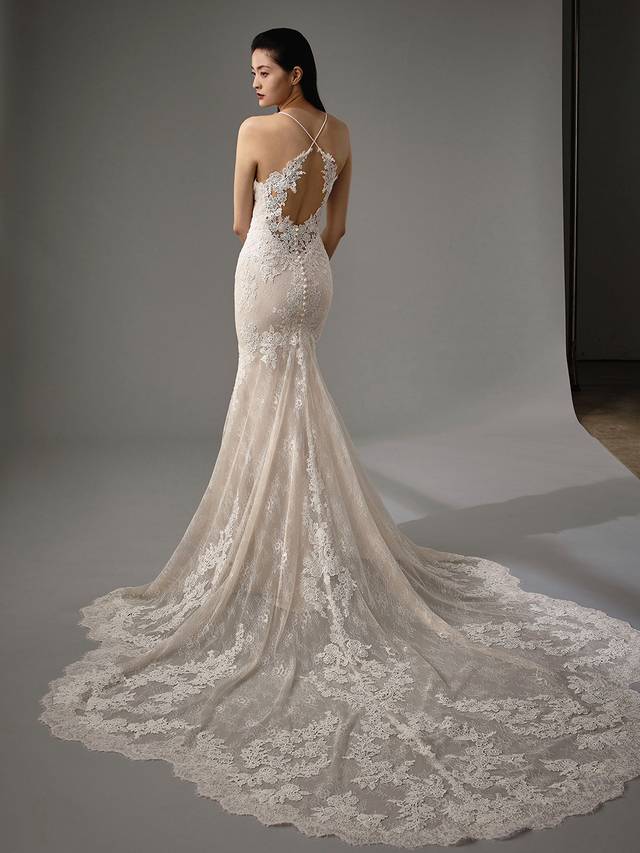 Code: Enzoani Blue - Miller Code: Enzoani Blue - Miller Romantic and elegant, this mermaid gown ensures all eyes will be on the bride. Gorgeous overlace adorns the illusion sweetheart neckline, trailing to the bodice and skirt. Delicate straps criss-cross over the back to create an eye-catchingl keyhole back. A sweet statement train and covered buttons complete the look.Colour Options: Ivory/Sand OR Ivory/Ivory OR Ivory/Nude