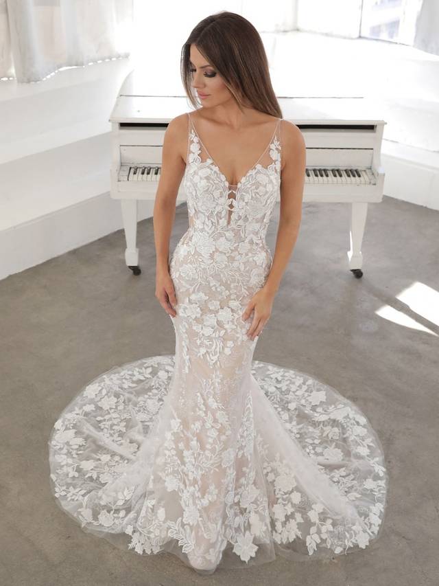 Code: Enzoani Blue Nefertiti - IN STUDIO Code: Enzoani Blue Nefertiti - IN STUDIO This form-fitting, sheath-style dress is paired with a romantic, detachable A-line skirt for two gorgeous looks in one. Designed with floral embroidered lace and sequin floral lace, NEFERTITI is in no shortage of exquisite detailing. For a hint of sparkle, a soft layer of glitter tulle and delicate beading rests beneath the front neckline. The V-shaped, illusion side cut-outs work in harmony with the bodice boning to provide the most structure and flattering shape.Colour Options: Ivory/Nude/Nude OR Ivory/Ivory/Ivory OR Ivory/Ivory/Nude OR Ivory/Sand/Nude